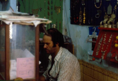 "Sion Houri" assis de profil dans sa bijouterie à houmt souk